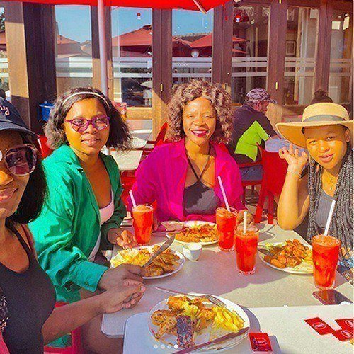 Ladies sitting in the sun enjoying their Wimpy meals