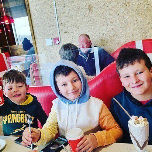 Kids sitting at table enjoying milkshakes and coffee