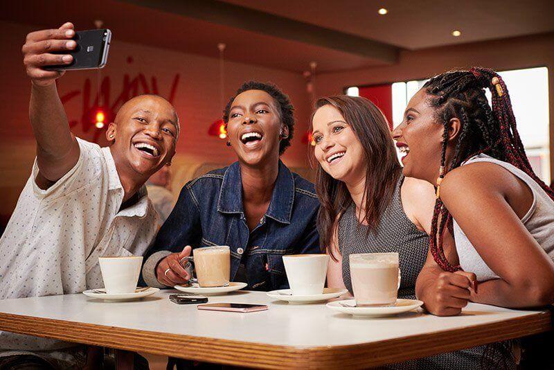 Four people taking a selfie at a Wimpy restaurant