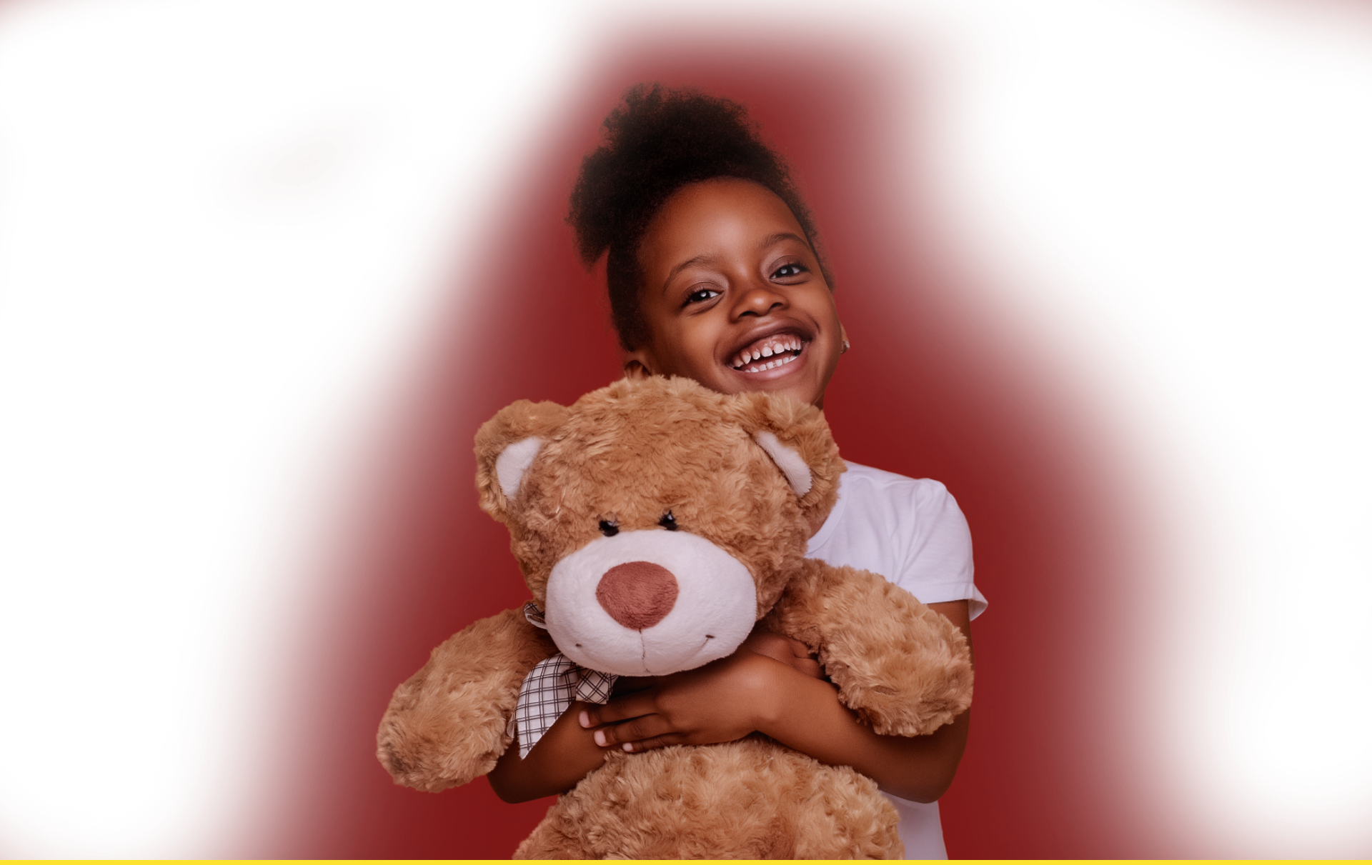 Smiling young girl holding a teddy bear against a red abstract background