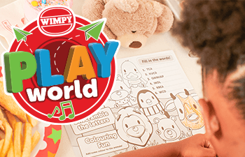 A young girl using a colouring activity printout at Wimpy.
