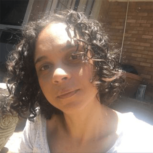 Tracy-Lee Easthorpe, author of How the Owl Got Its Sound, in a white shirt looking at a camera