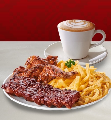 Delicious rack of ribs, chicken wings with sauce served with chips and a cappuccino