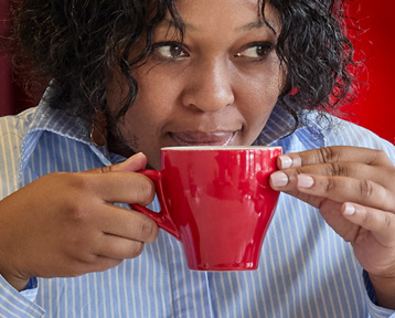 Lady drinking coffee out of red cup